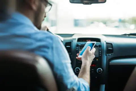 In The UK, Using Your Phone While Riding On The Passenger Seat Can Get You Fined