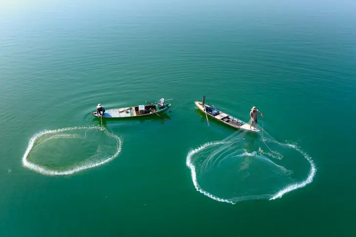 How should you pass a fishing boat?