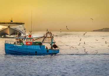 How should you pass a fishing boat?